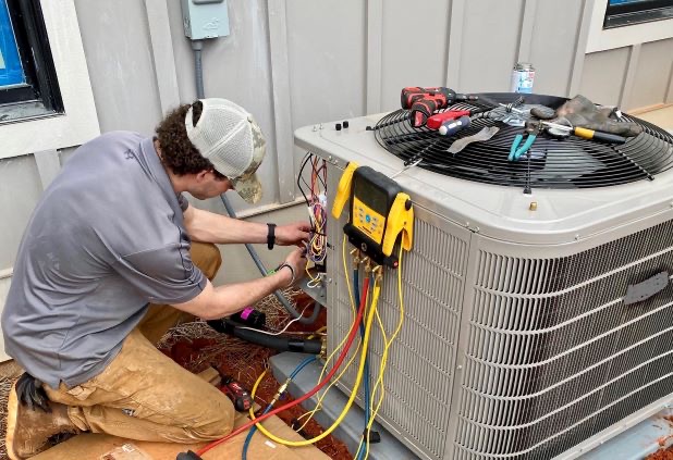 HVAC technician inspecting air conditioner