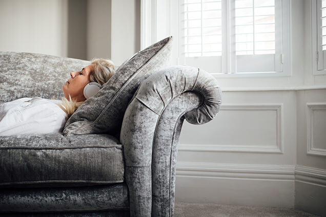 Woman Relaxing on Couch with Heating in Her Home